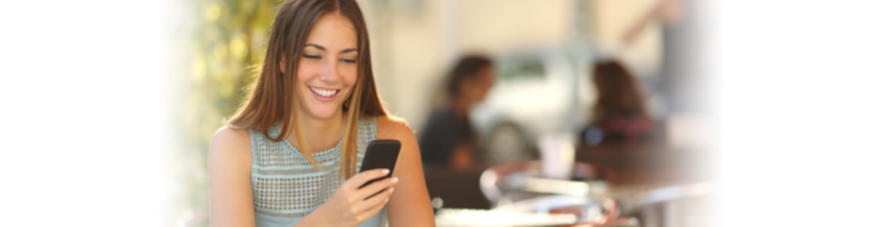 Woman Smiling and Using Smart Phone